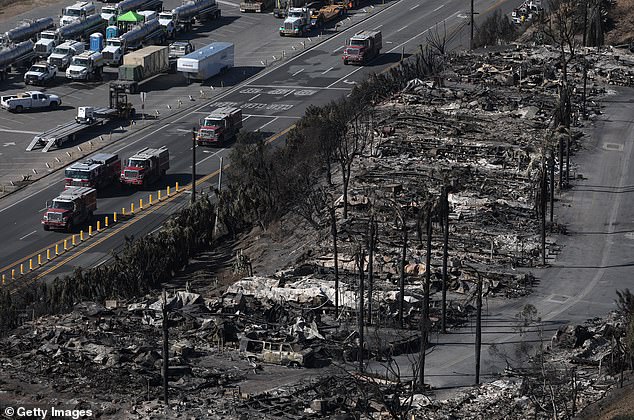 Fire trucks drive past a mobile home park that was destroyed by the Palisades Fire