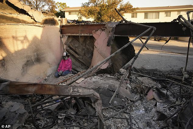 A woman sits as she picks through the rubble of her mother's home after it was destroyed by the Palisades Fire