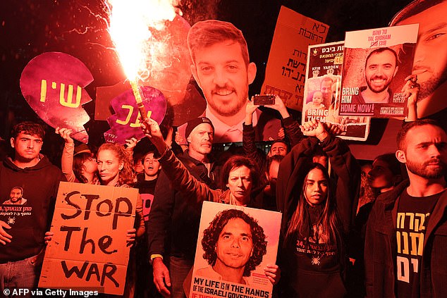 Protesters gather with signs during an anti-government protest calling for action to secure the release of Israelis held hostage in Gaza, outside the Israeli Ministry of Defense headquarters.