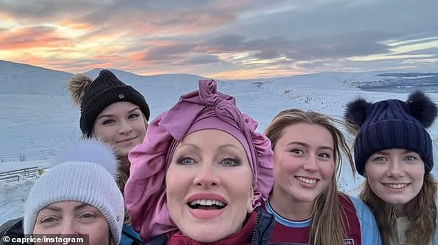 The model posed for selfies in the snow with her cast and crew during the shoot