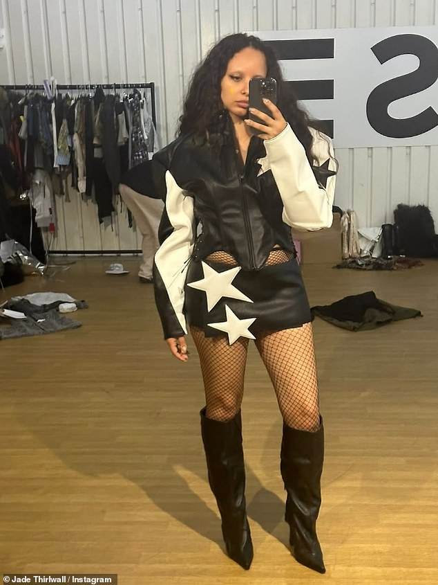 She added a pair of sky-high knee-high boots and a cropped leather jacket that showed off her toned midriff as she shot scenes while standing on a table.