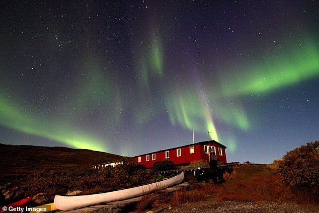 The Aurora Borealis glows above a hut near the town of Kangerlussuaq, September 2, 2007, in the Greenland city of Kangerlussuaq