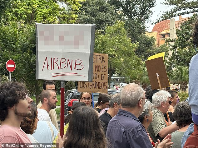 A sign reads 'F*** AirBnB', expressing frustration with the holiday home rental company