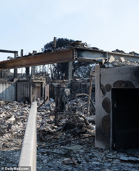 A look inside the wreckage shows the remains of the mansion's foundation and the lower door that was accessed from the driveway on the right. A burned basketball hoop that was on the left high wall is visible