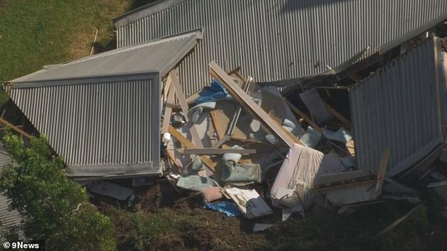 One person has been taken to hospital in a stable condition following the incident as SES crews work to clear the area (photo of house toppled by landslide)