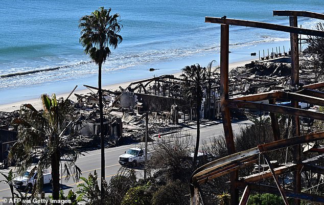 Gas and electric vehicles making repairs pass beachside properties destroyed by fire from the Palisades Fire along the Pacific Coast Highway in Malibu, California on January 12, 2025.