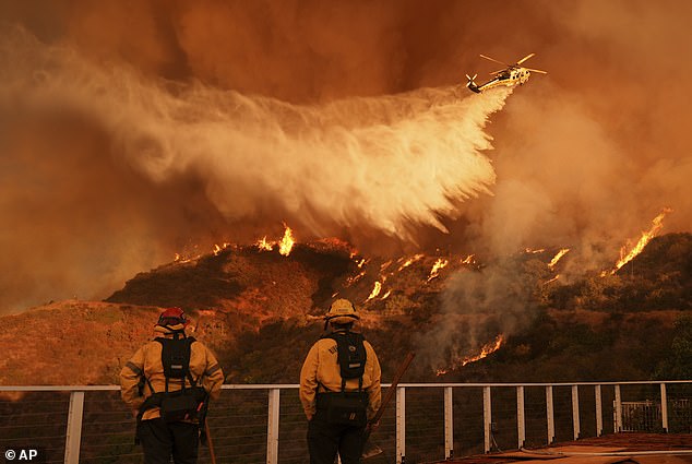 Firefighters watch as water is dropped on the Palisades Fire in Mandeville Canyon Saturday, January 11, 2025