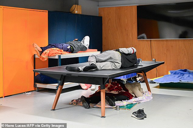 Photos from inside the theater show people sleeping on tables in cramped conditions