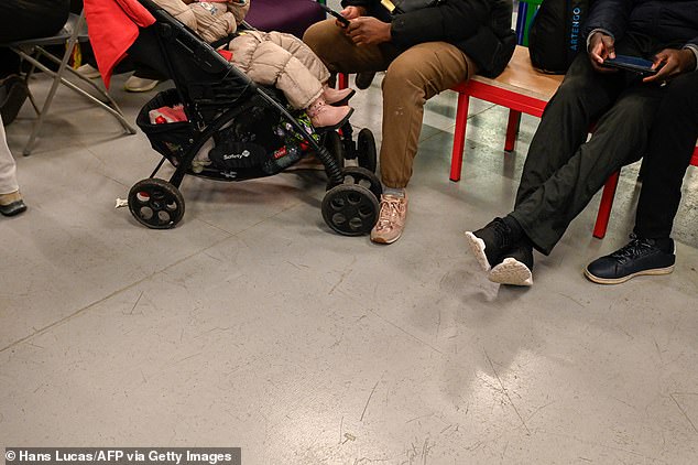 A small child is seen in a buggy as people seek shelter in the theater