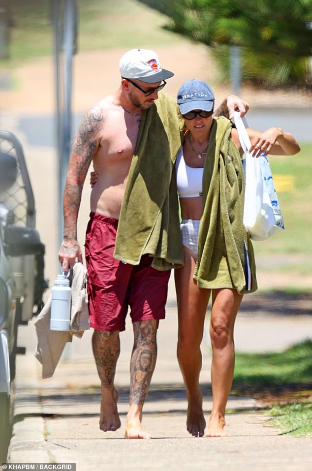 When the couple arrived at the beach with green towels over their shoulders, Claire pulled a blue cap low over her face and hid her eyes behind dark sunglasses.