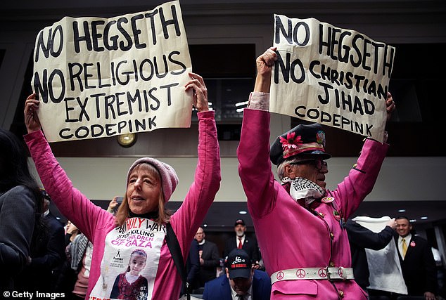 Protesters with the group CodePink demonstrate at the start of the Senate Armed Services confirmation hearing for President-elect Donald Trump's nominee for Defense Secretary Pete Hegseth on Capitol Hill