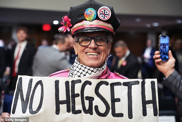 A protester holding an anti-Hegseth sign. He was later asked to leave