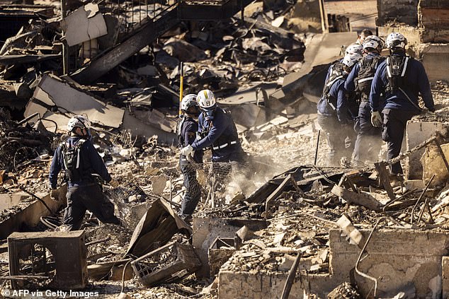 California Task Force 3 Urban Search and Rescue firefighters comb through the ruins of a beachside home for victims