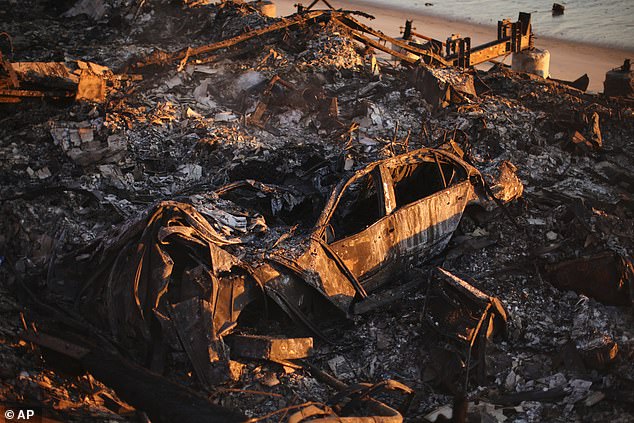 A burned-out car is seen among the wreckage of a home destroyed by the Palisades Fire