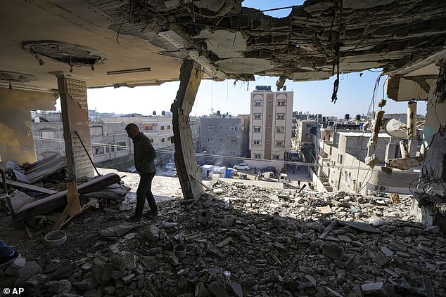 A Palestinian looks at a damaged residential building after an overnight Israeli attack in Deir al-Balah on January 8