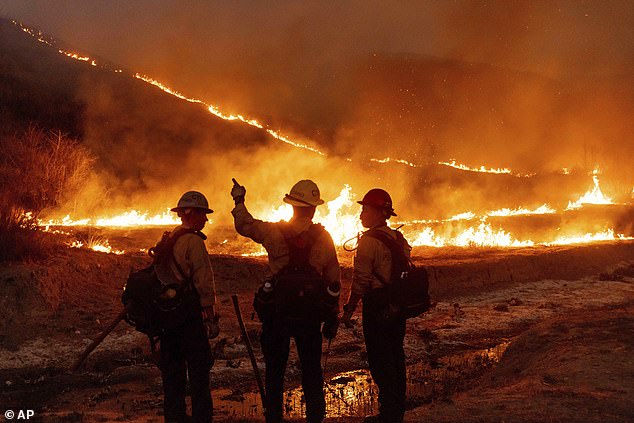 Firefighters are pictured battling the Kenneth Fire in the West Hills section of Los Angeles