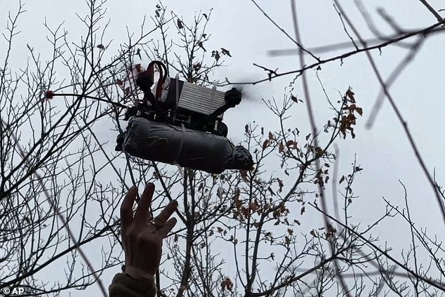 In this photo taken from a video released by the press service of the Russian Ministry of Defense on Monday, November 25, 2024, a Russian soldier launches an FPV drone towards Ukrainian position at a secret location