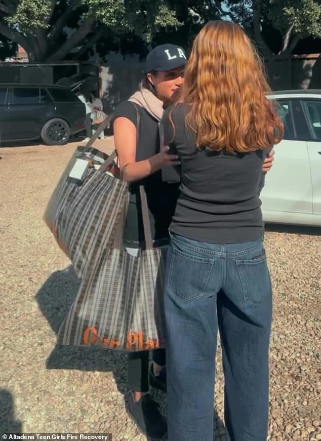 The mother of two looked cool, casual in jeans, a black T-shirt and a navy blue baseball cap with the letters 'LA' on it as she rubbed the girl's arm.