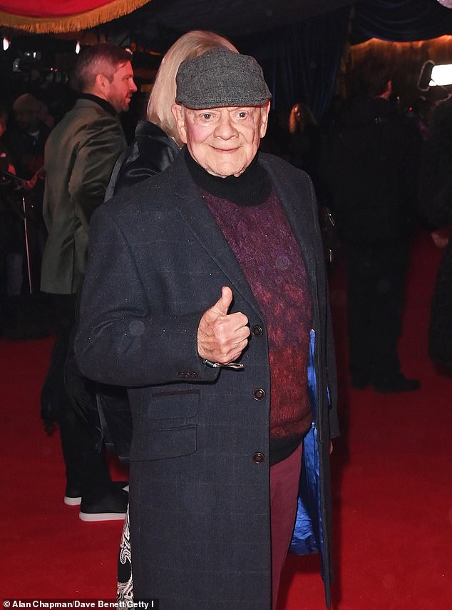 David, 84, who was smartly dressed in a gray trench coat and flat cap, gave a thumbs up to the cameras on the red carpet