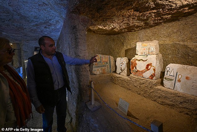 Head of Egypt's Supreme Council of Antiquities, Mohammad Ismail, shows and discusses fragments of stones depicting scenes of rituals during an indoor media event to announce new discoveries at the Valley Temple of Queen Hatshepsut