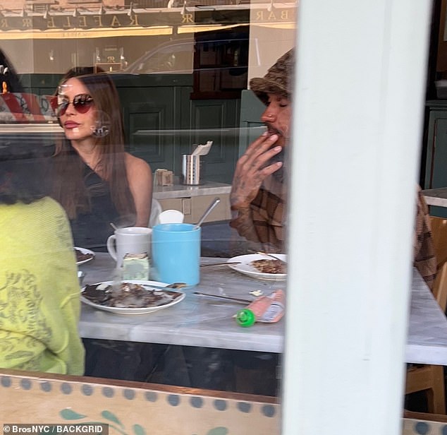 Sofia and Lewis sat next to each other at a restaurant table, where they were joined by friends