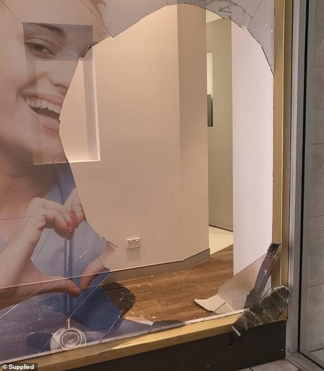 A neighboring storefront was damaged during the commotion of the alleged attack before the alleged attacker continued to punch the business owner