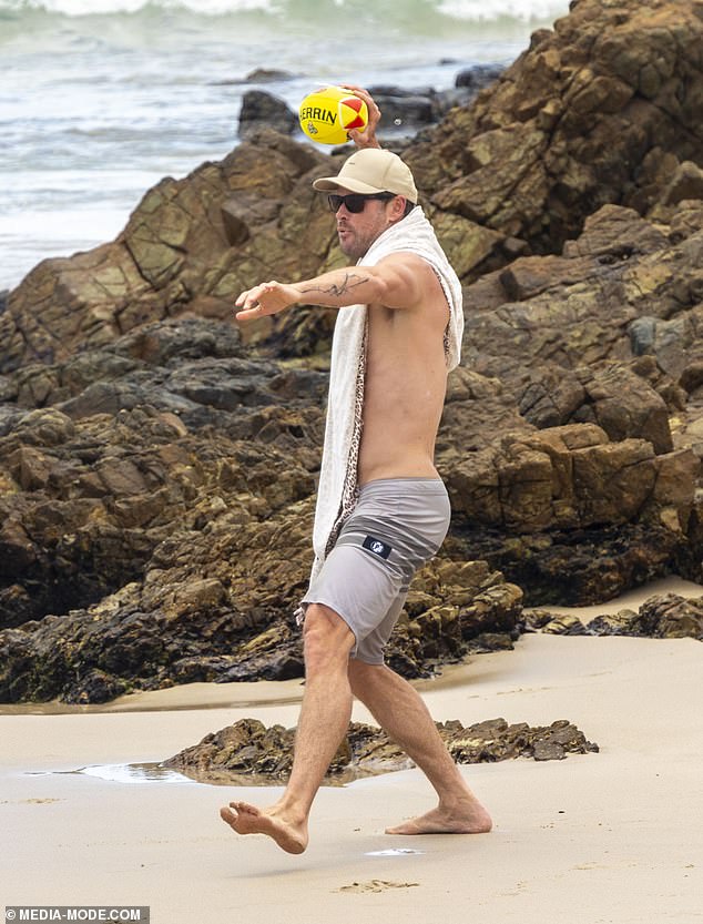 The Thor star looked handsome in a pair of gray board shorts that hung low on his ripped body