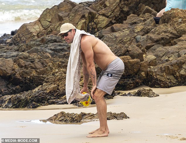 Wearing nothing but a pair of very tight shorts that showed off his toned legs, Chris looked completely at ease as he enjoyed the surf and sand.