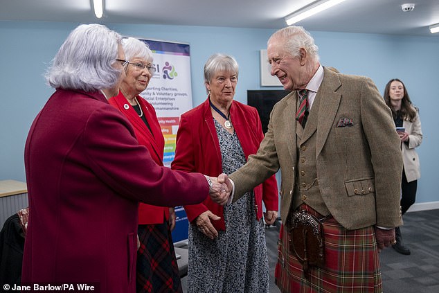 King Charles is pictured shaking hands with some of the charity's staff and volunteers