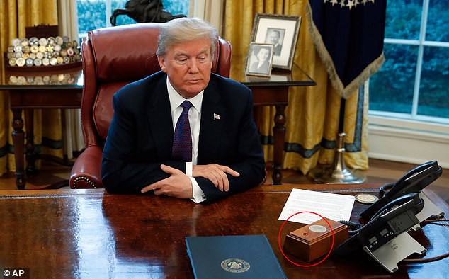 President Donald Trump sits at the Resolute Desk in the Oval Office – the Diet Coke button is circled in red