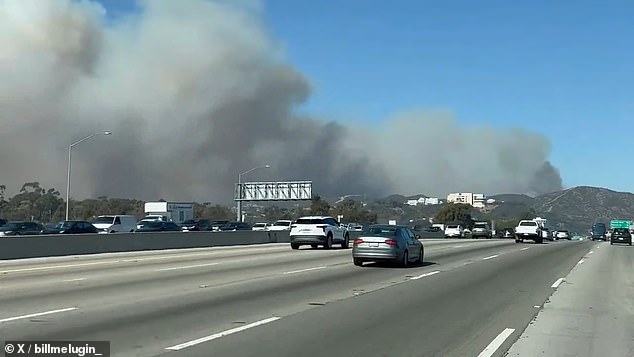 Images from earlier today show at least one house on fire in the canyon and huge clouds of smoke billowing near Sepulveda Pass off Highway 405