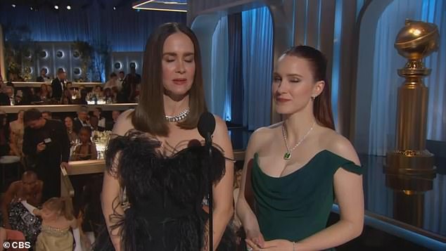 While Sarah Paulson and Rachel Brosnahan were on stage presenting an award, the two could be seen in the corner of the screen, with Grande leading Erivo by the hand as they tried to sneak out of the room.