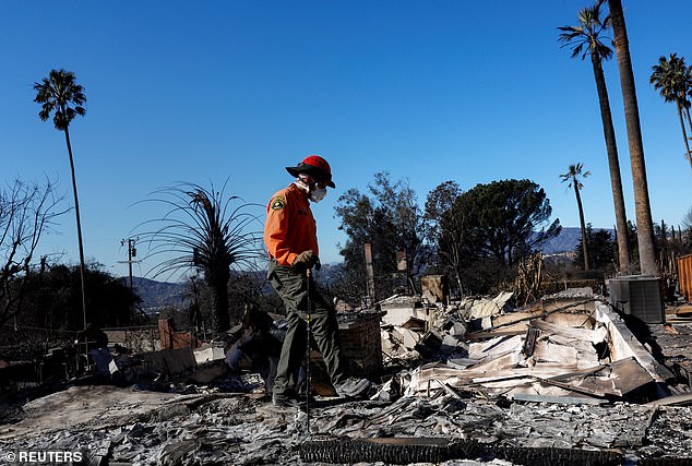 A search and rescue officer seen searching through the rubble in Altadena, California after the Eaton Fire destroyed the city