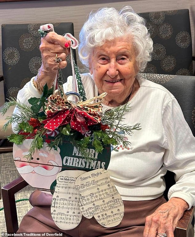 Florence smiles as she holds up a Christmas decoration