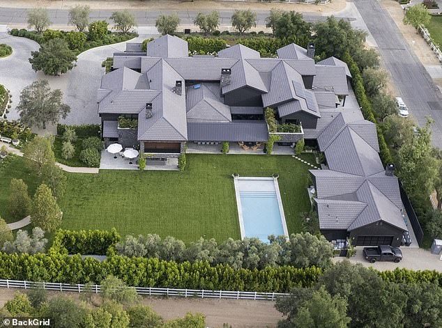 A photo of Khloe's sprawling Hidden Hills home with a large lawn in the backyard and a swimming pool