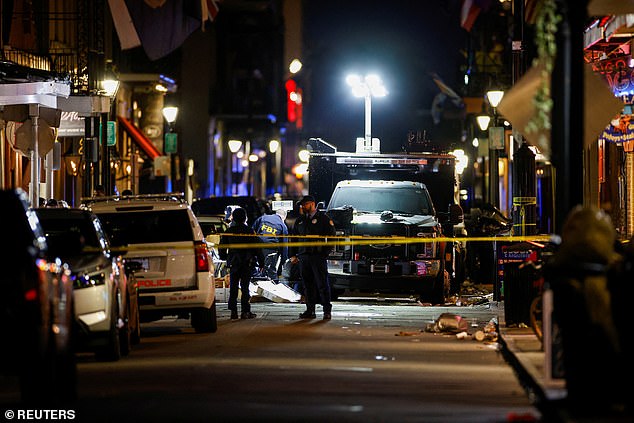 FBI agents look at the scene where people were killed by a man driving a truck during a terrorist attack