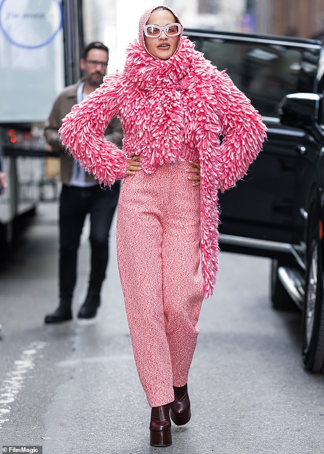 For her second look, the beauty made a statement by wearing pink tweed pants and a pink and white colored sweater.