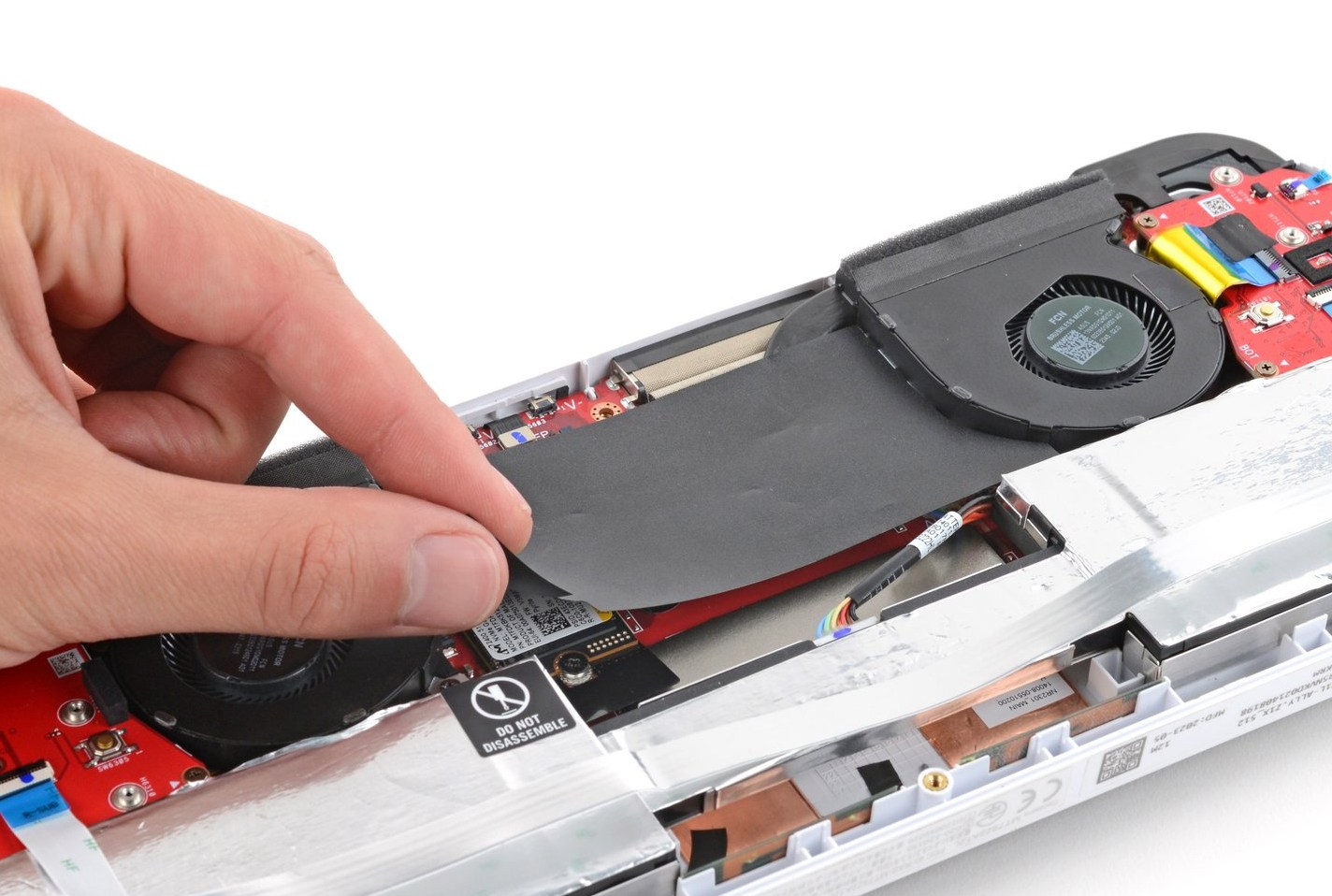 A photo of a hand removing the plastic covering ROG Ally's internal components