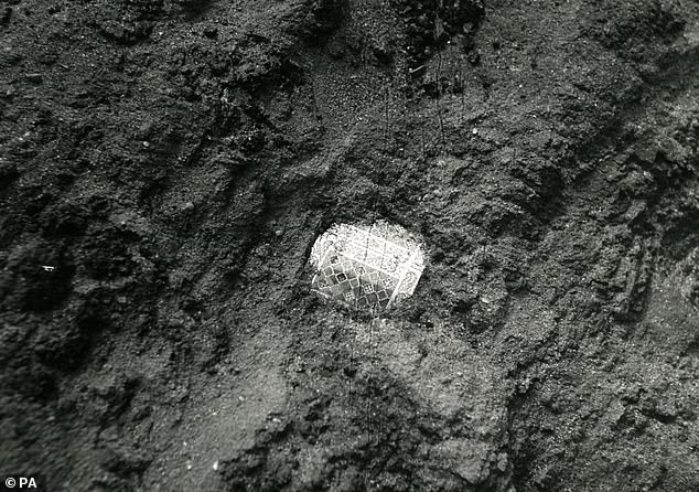 Photo by Trustees of the British Museum showing the discovery of a gold and garnet shoulder clasp from the ship burial mound at Sutton Hoo