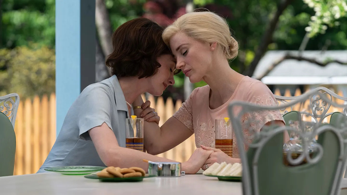 Anne Hathaway and Jessica Chastain lean close to each other in Mothers' Instinct