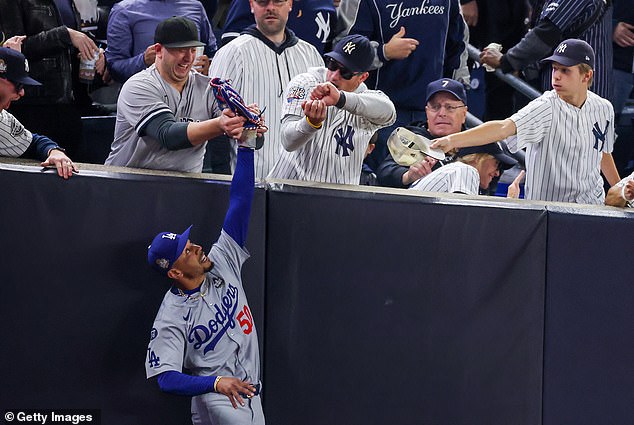 The fans were ejected after trying to snatch the ball from Mookie Betts' glove